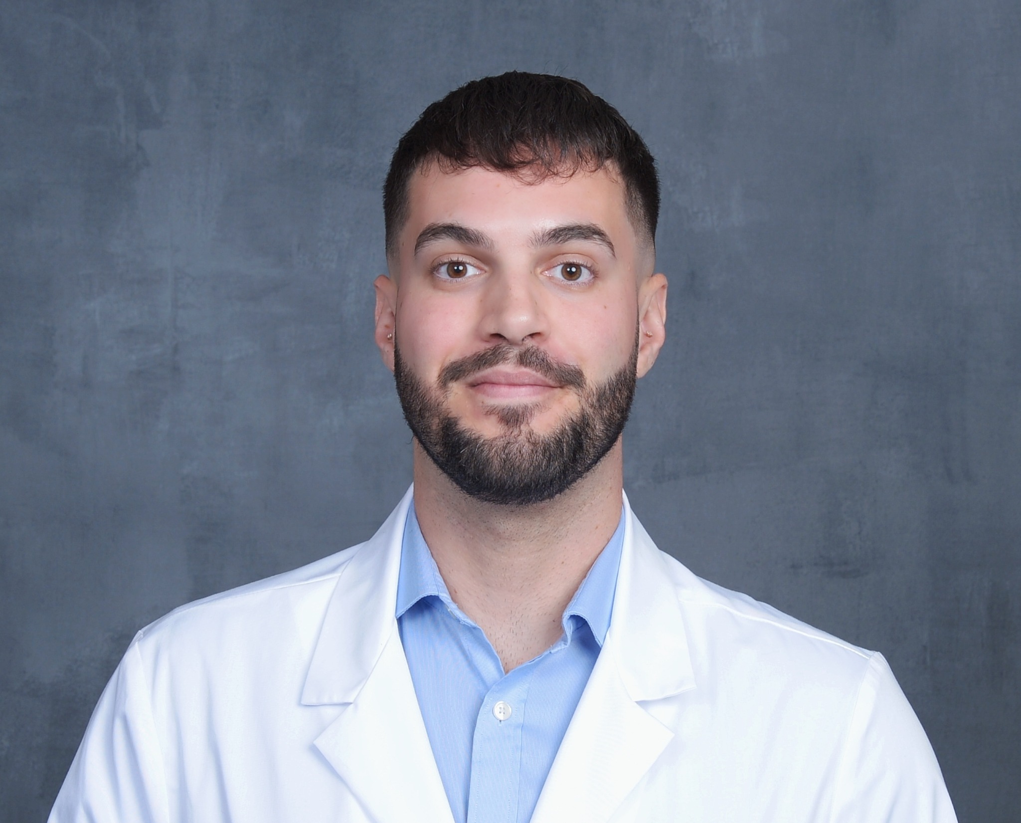 Aaron Riffa wearing a white clinical coat